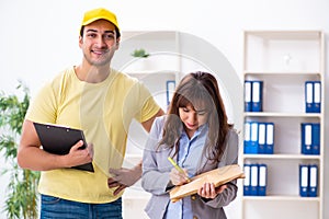 Young male courier delivering parcel to the office