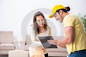 Young male courier delivering parcel to the office