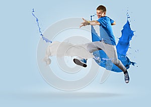 Young male dancer jumping with splash of paint