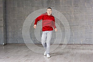 Young male dancer posing on studio background.