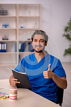 Young male dentist working in the clinic