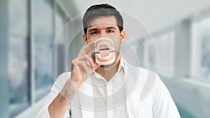 Young male dentist working in dental clinic.