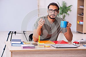 Young male designer drinking coffee in the office