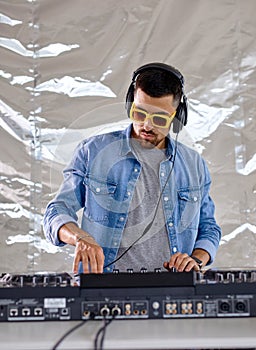 young male DJ playing music in studio, caucasian man in casual wear perform club music
