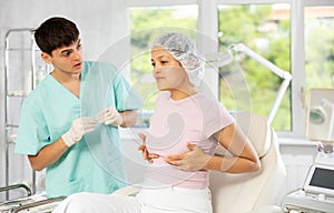 Young male doctor consulting female client on breast augmentation