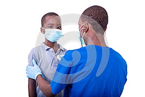 A young male doctor examining a little boy with a stethoscope