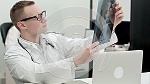 Young male doctor examining x-ray images