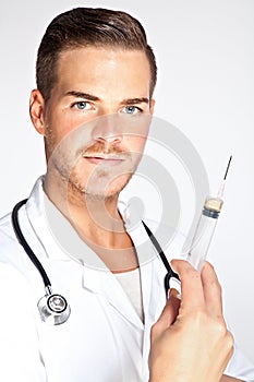 Young male doctor holding syringe with injection photo