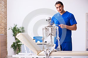 Young male doctor lecturer demonstrating skeleton