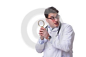 Young male doctor with a looking magnifying glass isolated on wh