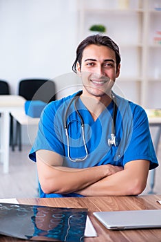 Young male doctor looking at x-ray images