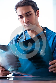 Young male doctor looking at x-ray images