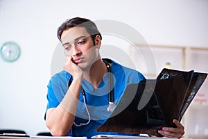 Young male doctor looking at x-ray images