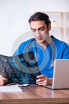 Young male doctor looking at x-ray images