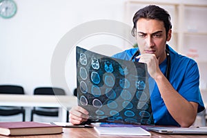 Young male doctor looking at x-ray images