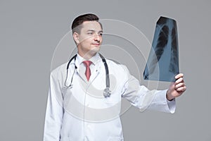 Young male doctor looking at the x-ray picture of lungs.