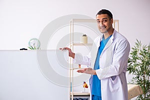 Young male doctor in presentation concept