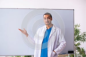 Young male doctor in presentation concept