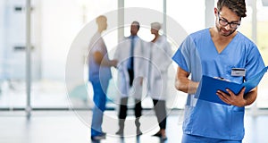 Young male doctor reading, holding and looking at patient health information at a hospital. Medical professional