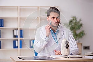 Young male doctor in remuneration concept