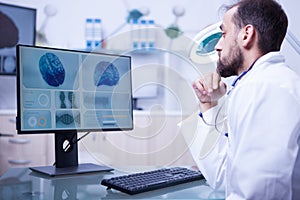 Young male doctor specialised in brain tumor checking a bran in hospital laboratory photo