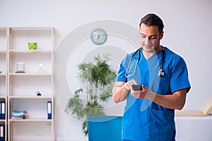 Young male doctor using smartphone in telemedicine concept