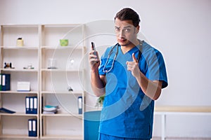 Young male doctor using smartphone in telemedicine concept