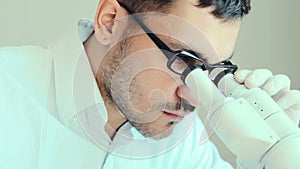 Young male doctor viewing through microscope