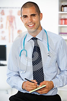 Young male doctor writing prescription