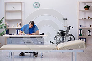 Young male doctor writing prescription in the clinic