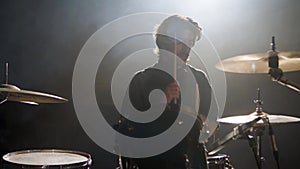 Young male drummer playing drums at music studio