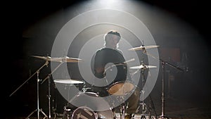Young male drummer playing drums at music studio