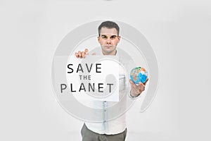 Young male ecologist holding paper placard with Save The Earth text, and little globe in hands, standing isolated over