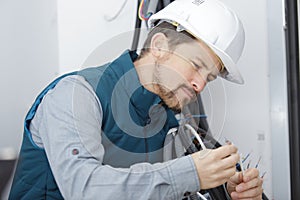 Young male electrician examining wiring