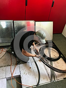 Electrician removes floor panels to get to cables