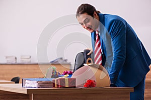 Young male employee celebrating Christmas at workplace