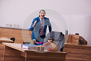 Young male employee celebrating Christmas at workplace