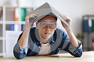 Young Male Employee Covering Head With Opened Laptop, Suffering Deadine Stress