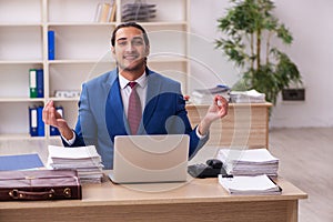 Young male employee doing yoga exercises during break