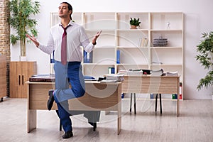 Young male employee doing yoga exercises during break