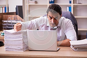 Young male employee extremely tired with excessive work