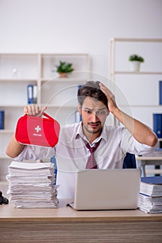 Young male employee feeling bad at workplace