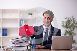 Young male employee in first aid concept