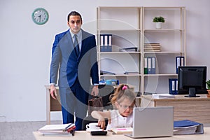 Young male employee and his little girl in the office