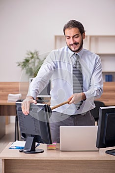 Young male employee holding plunger in funny concept