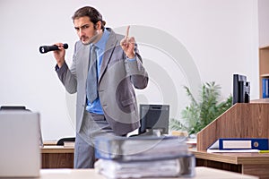 Young male employee in industrial espionage concept