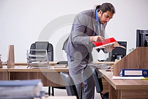 Young male employee in industrial espionage concept