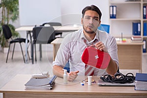 Young male employee suffering at workplace