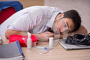 Young male employee suffering at workplace