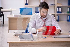 Young male employee suffering at workplace